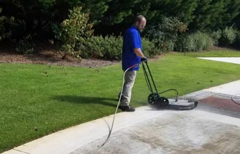 a man cleaning the paver in the yard