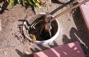 A plumber unclogs a sewer drain with his Plumbing Snake and tools.