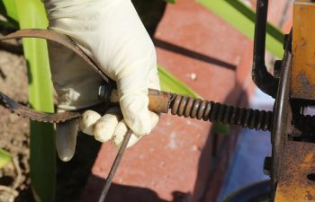 A plumber unclogs a sewer drain with his Plumbing Snake and tools