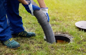 A technician pumping out a septic tank.