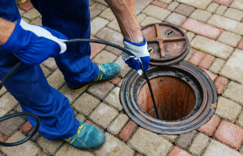 worker clean a clogged drainage with hydro jetting
